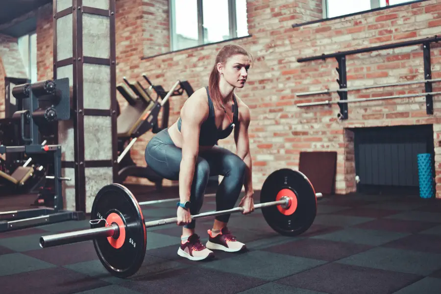 Woman deadlifting on rubber tiles